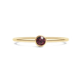 Gold ring with a red gemstone on a white background