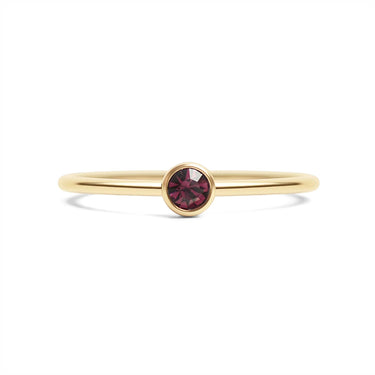 Gold ring with a red gemstone on a white background