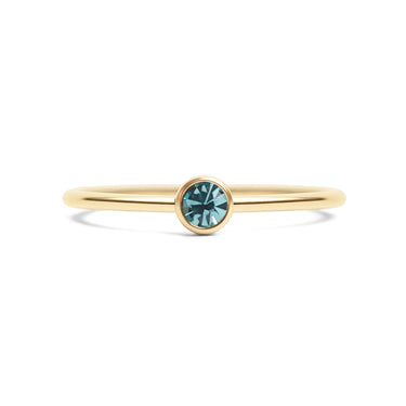 Gold ring with a blue gemstone on a white background