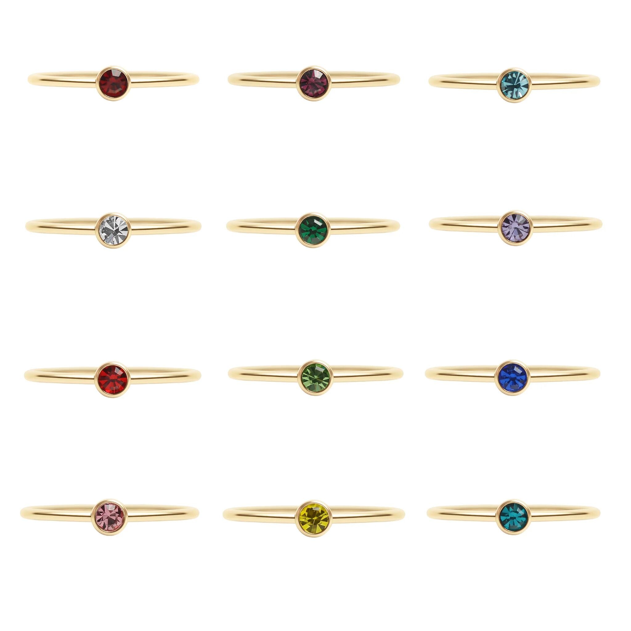 Gold rings with colorful gemstones on a white background