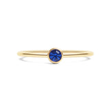 Gold ring with a blue gemstone on a white background