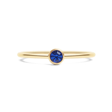 Gold ring with a blue gemstone on a white background