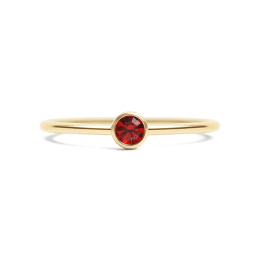 Gold ring with a red gemstone on a white background