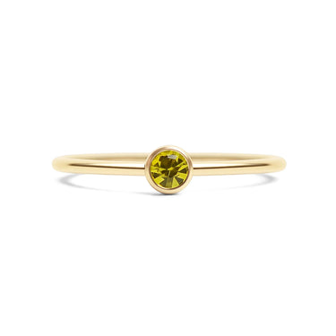Gold ring with a yellow gemstone on a white background