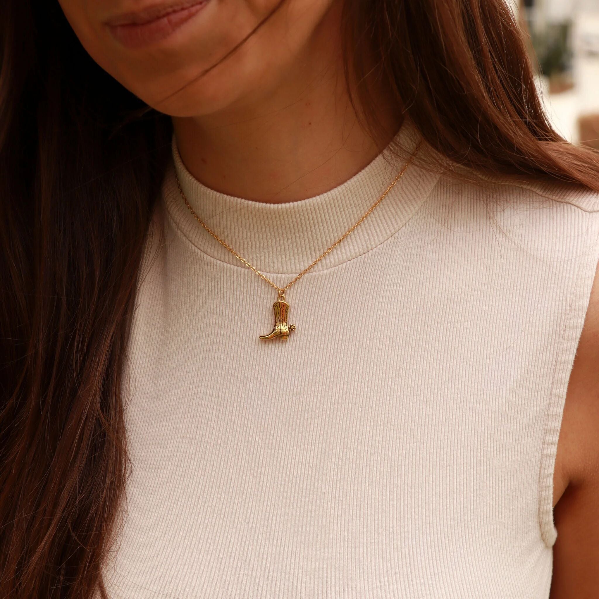 Close-up of a person wearing a gold necklace with a pendant.