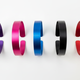 Five colored aluminum cuff bracelets - purple, pink, blue, black, and red