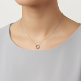 Stainless steel circle pendant worn on chain by model