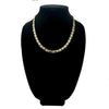A stainless steel and gold color necklace on a black velvet bust.