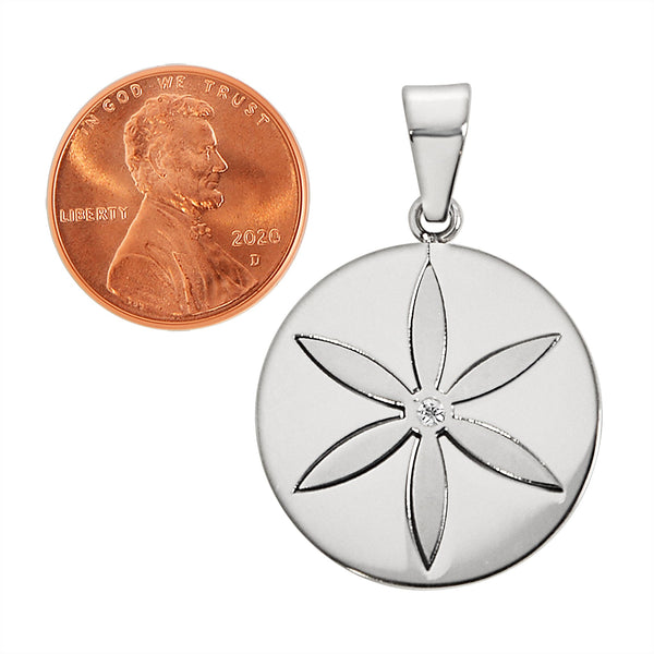Stainless steel round Cubic Zirconia center flower pendant with a penny for scale.