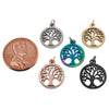 Stainless steel tree of life charm in a variety of different colors with a penny for scale.