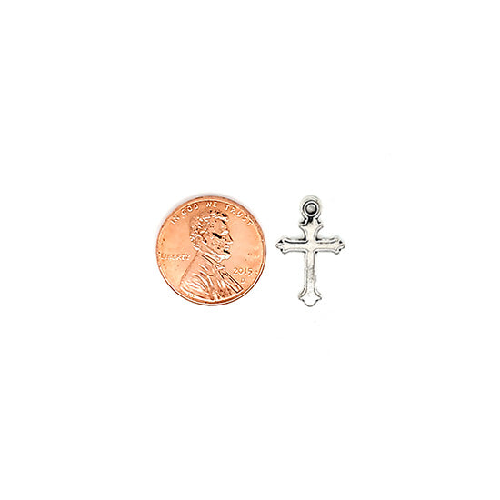 Small cross charm with a penny for scale.