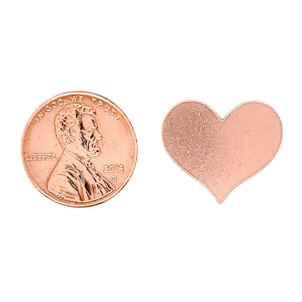 Copper blank heart pendant with a penny for scale.