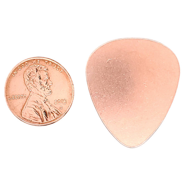 Copper blank guitar pick pendant with a penny for scale.