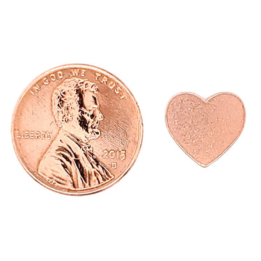 Copper blank heart pendant with a penny for scale.