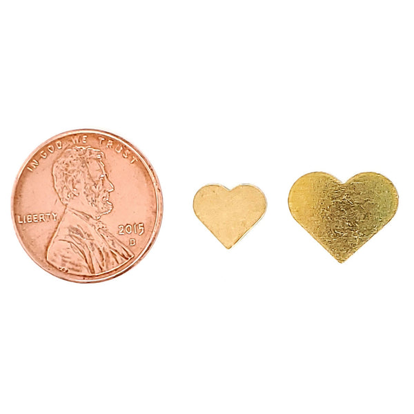 Brass blank heart pendant in two different sizes with a penny for scale.