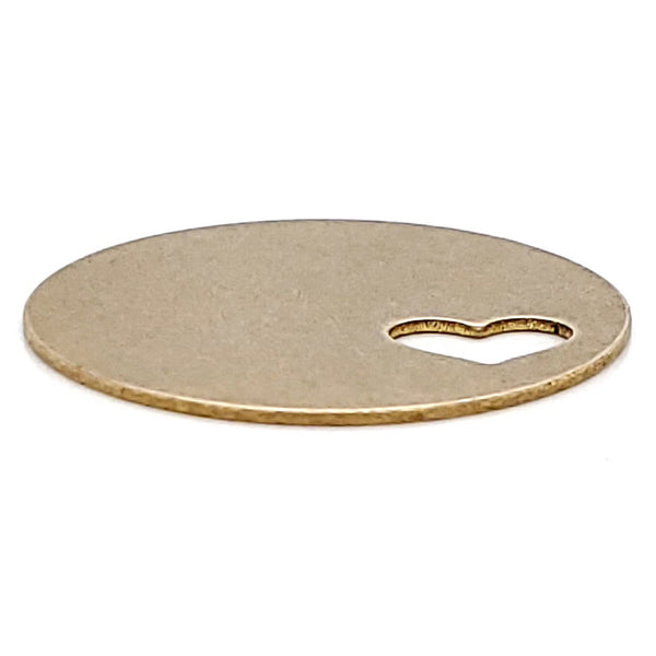 Brass blank round heart cutout pendant at an angle.