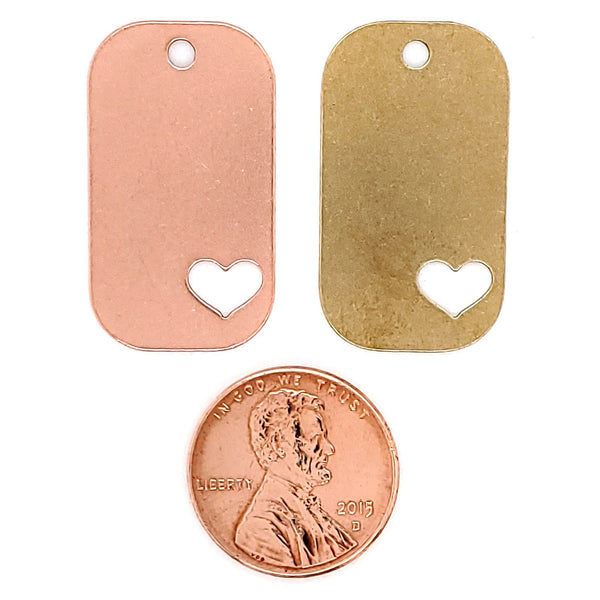 Copper and brass blank heart cutout dog tag pendants with a penny for scale.