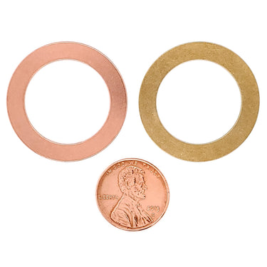 Copper and brass blank washer pendants with a penny for scale.