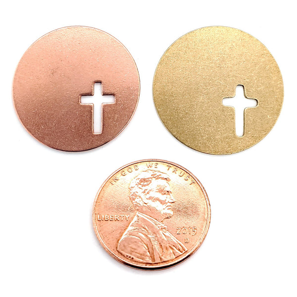 Copper and brass blank round cross cutout pendants with a penny for scale.
