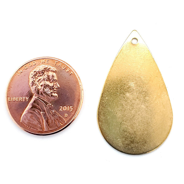 Brass blank rain drop pendant with a penny for scale.