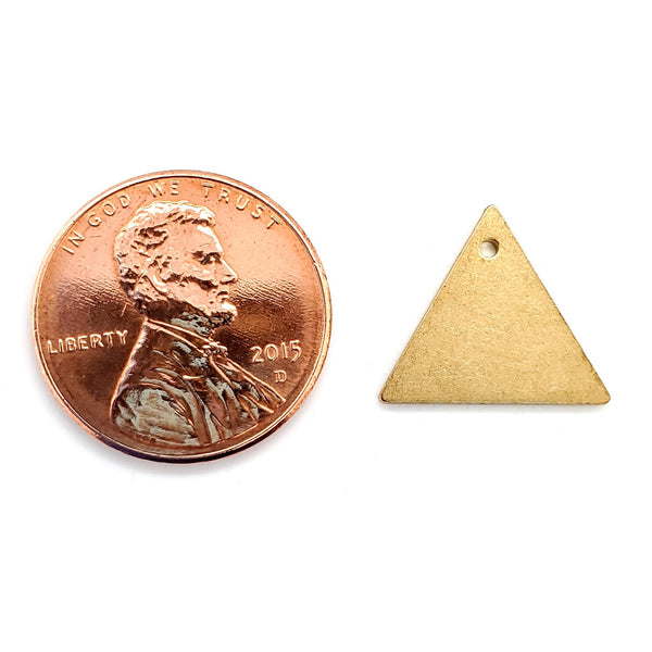 Brass blank triangle pendant with a penny for scale.