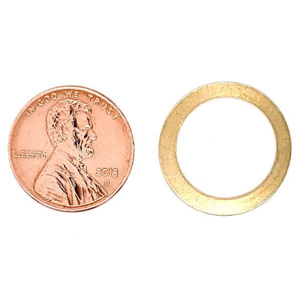Brass blank washer pendant with a penny for scale.