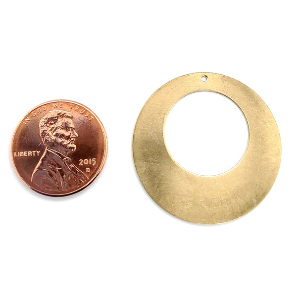 Brass blank holed washer pendant with a penny for scale.
