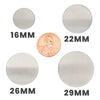 Stainless steel blank round pendants in a variety of sizes with a penny for scale.