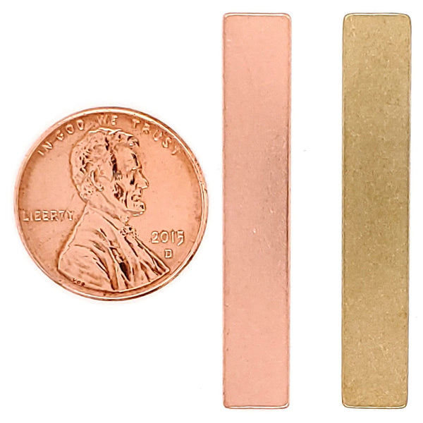 Copper and Brass blank rectangle pendants with a penny for scale.