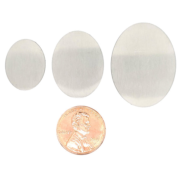 Stainless steel blank oval pendant in a variety of sizes with a penny for scale.