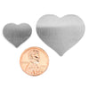 Stainless steel blank heart pendant in two sizes with a penny for scale.