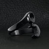 Stainless steel black wrench ring angled on a black leather background.