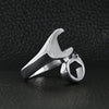 Stainless steel wrench ring angled on a black leather background.