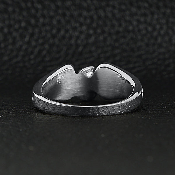 Stainless steel polished winged wheel ring back view on a black leather background.