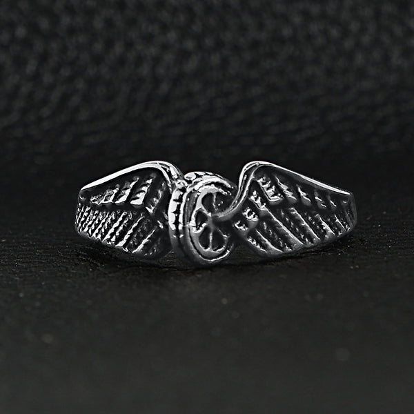 Stainless steel polished winged wheel ring on a black leather background.