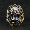 Stainless steel red Cubic Zirconia eyed flaming skull with 18K gold PVD Coated accents and Maltese Cross ring on a black leather background.