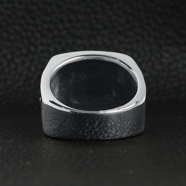Stainless steel polished Maltese Cross ring back view on a black leather background.