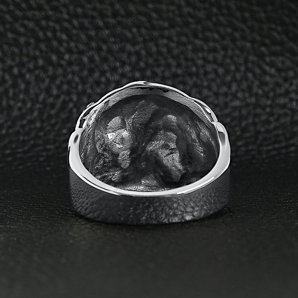 Stainless steel skull with red Cubic Zirconia eye and eyepatch ring back view on a black leather background.