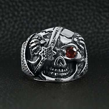 Stainless steel skull with red Cubic Zirconia eye and eyepatch ring on a black leather background.