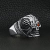 Stainless steel skull with red Cubic Zirconia eye and eyepatch ring angled on a black leather background.