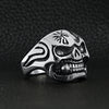 Stainless steel polished skull with cigar ring angled on a black leather background.