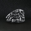 Stainless steel polished multiple skulls ring angled on a black leather background.