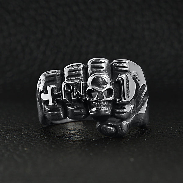 Stainless steel biker rings fist ring on a black leather background.