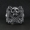 Stainless steel polished studded skull ring on a black leather background.