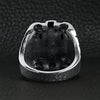 Stainless steel polished multi skull Cross ring back view on a black leather background.