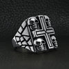 Stainless steel polished multi skull Cross ring angled on a black leather background.