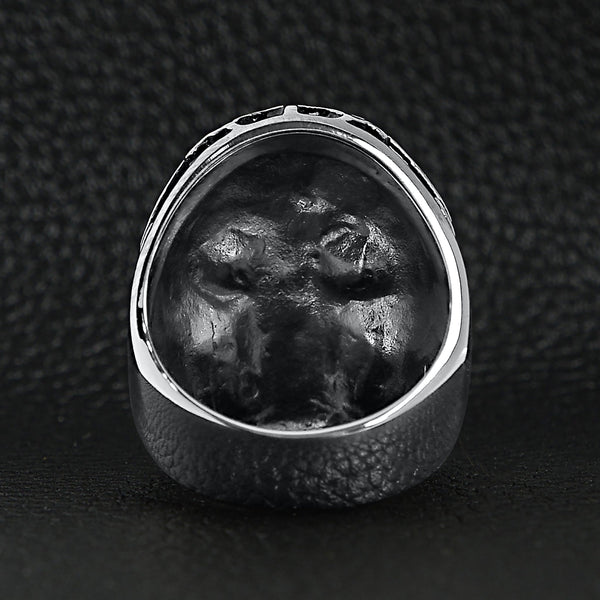 Stainless steel polished red Cubic Zirconia eyed filigree skull ring back view on a black leather background.