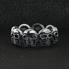 Stainless steel polished multi skull ring on a black leather background.