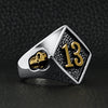 Stainless steel 18K gold PVD Coated accents "13" and skulls ring angled on a black leather background.
