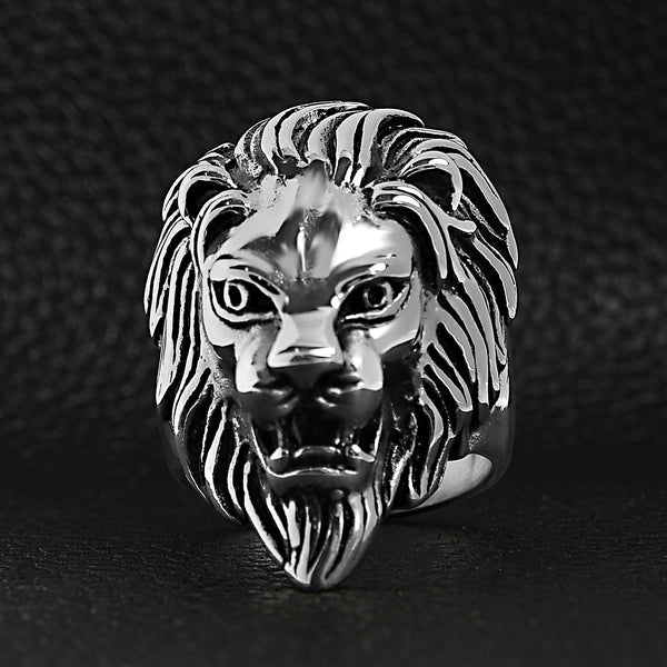 Stainless steel roaring lion head ring on a black leather background.